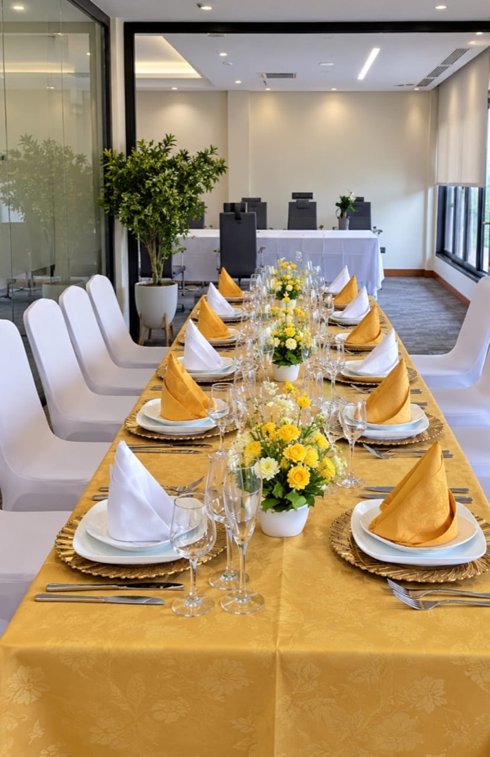 Table de réunion dressée, serviettes dorées